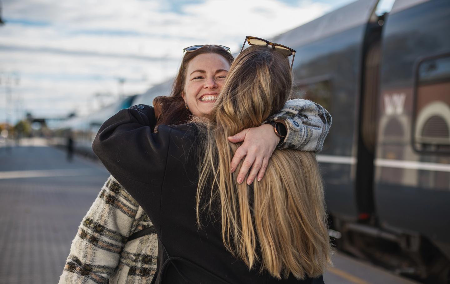 Two women giving each other a hug while travelling